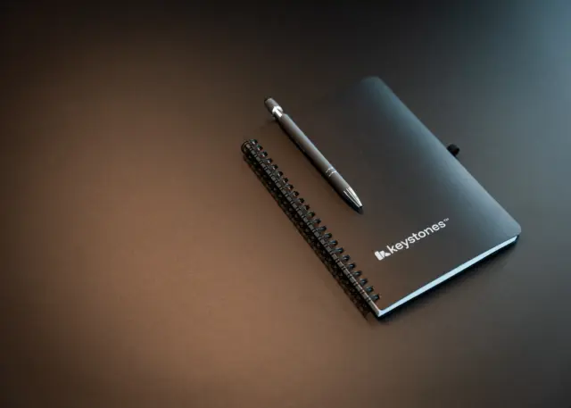 En sort notatbok merket med Keystones sin logo